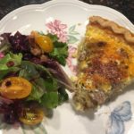 dining plate with slice of sausage quiche and side salad