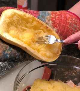 using a fork to scrape meat from spaghetti squash shell